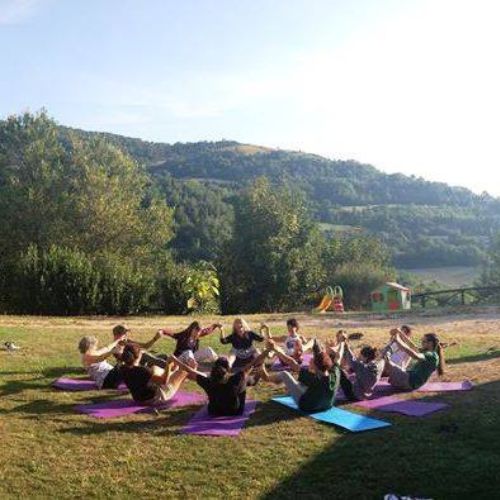 Gruppo di persone sedute su di un prato in aperta campagna