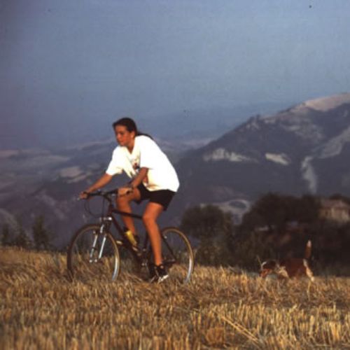 Ragazza che scalta la collina con la bicicletta